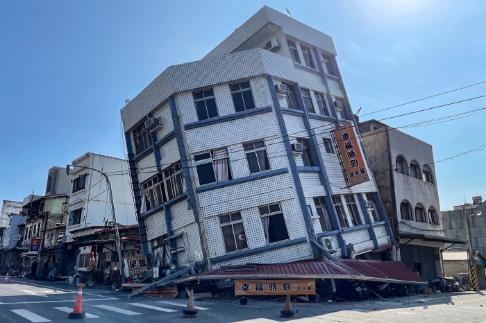 A damaged building tilts to its side