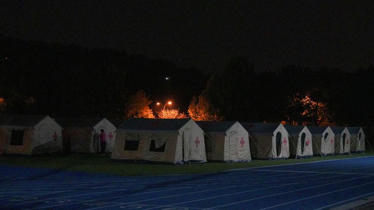 A person stands in between tents set up in a school used as a shelter, following an earthquake, in Hualien, Taiwan April 3, 2024. REUTERS/Walid Berrazeg