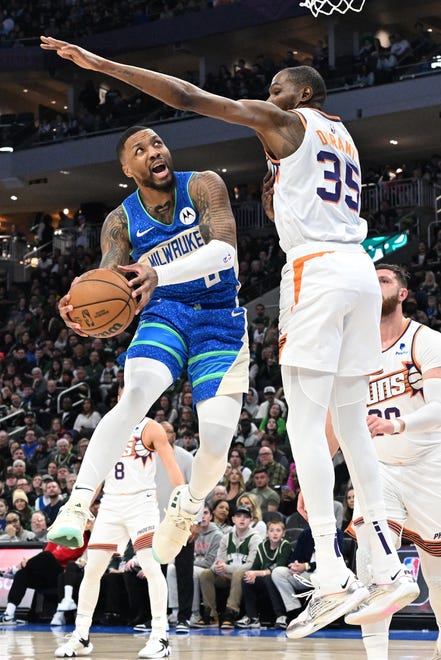 Mar 17, 2024; Milwaukee, Wisconsin, USA; Milwaukee Bucks guard Damian Lillard (0) drives to the basket against Phoenix Suns forward Kevin Durant (35) int he first half at Fiserv Forum. Mandatory Credit: Michael McLoone-USA TODAY Sports