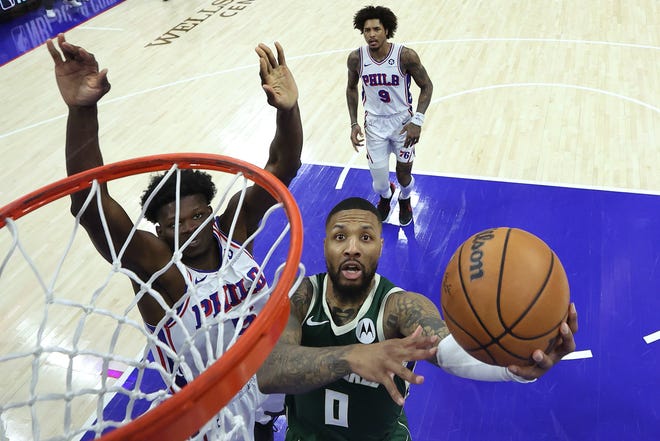 Bucks guard Damian Lillard gets past 76ers center Mo Bamba for a layup during the third quarter Sunday at Wells Fargo Center in Philadelphia.