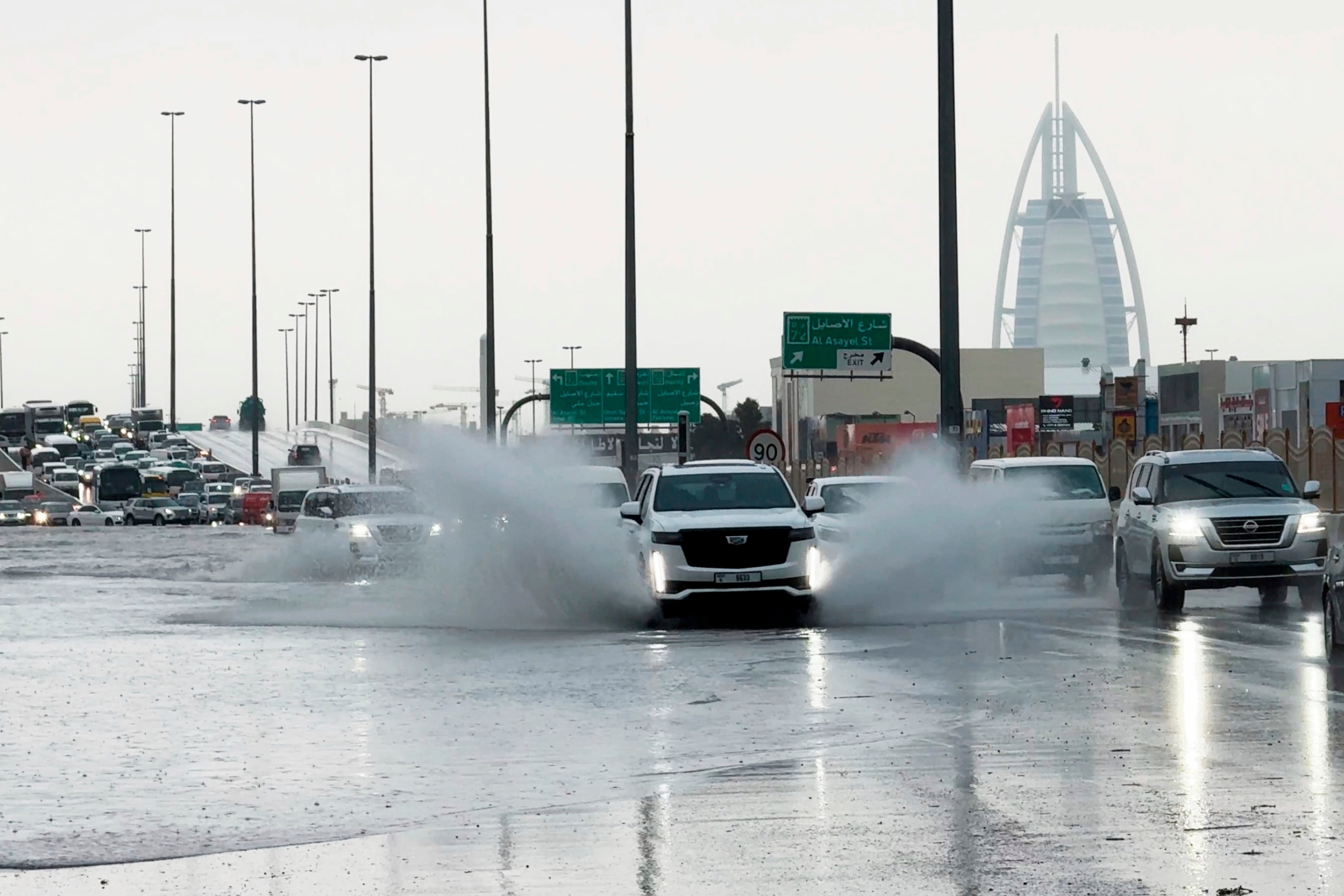 PHOTO: An SUV splashes through standing water on a road with the Burj Al Arab luxury hotel seen in the background in Dubai, United Arab Emirates, April 16, 2024. 