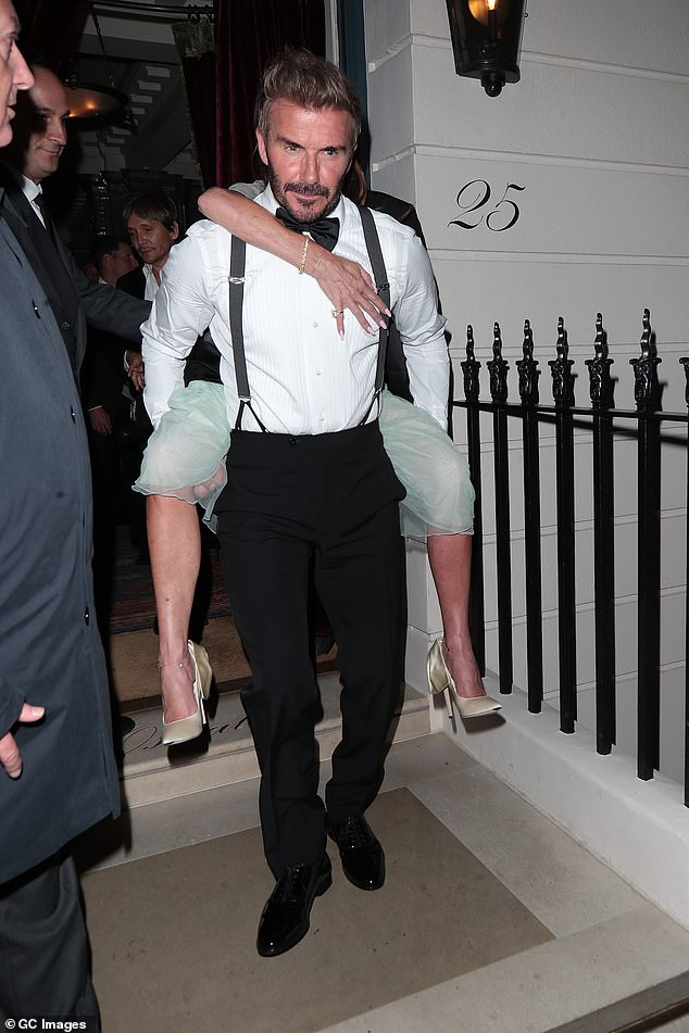 David gripped his wife's legs while carrying her out of Oswalds, an exclusive members-only club in London's Mayfair