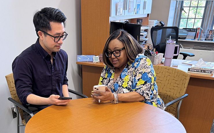 Brenetta Tate works with new faculty member Tony Cheng during an onboarding session.