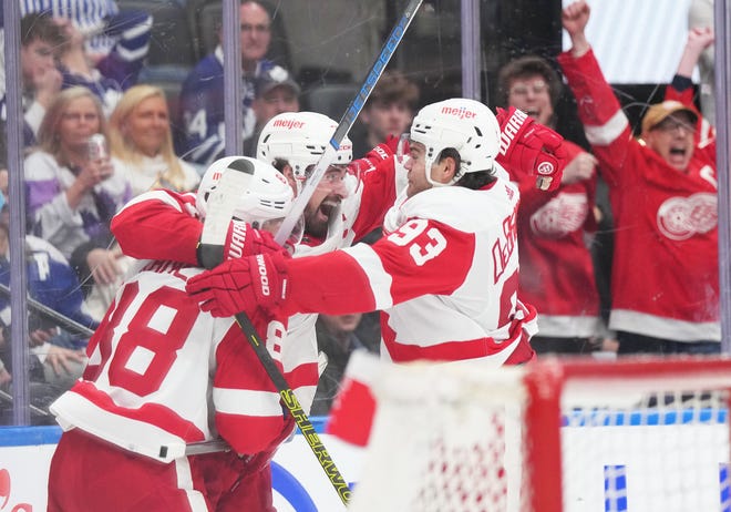 Red Wings center Dylan Larkin scores the winning goal and celebrates with right wing Alex DeBrincat (93) during the overtime period of the Red Wings' 5-4 win on Saturday, April 13, 2024, in Toronto.