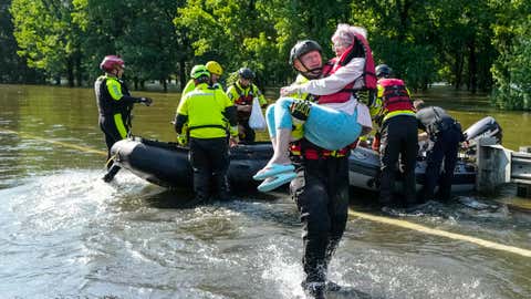 CONROE, TEXAS - MAY 2: The Conroe firefighter Cody Leroy carries a resident evacuated in a boat by the CFD Rapid Intervention Team from her flooded home in the aftermath of a severe storm on Thursday, May 2, 2024 in Conroe. The rising water from the West Fork of the San Jacinto River, downstream from Lake Conroe, flooded homes and roads along FM 2854. (Brett Coomer/Houston Chronicle via Getty Images)