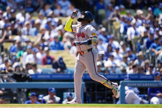 Atlanta Braves designated hitter Marcell Ozuna celebrates after hitting a...