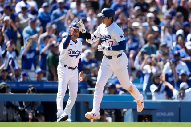 Los Angeles Dodgers designated hitter Shohei Ohtani celebrates with third...