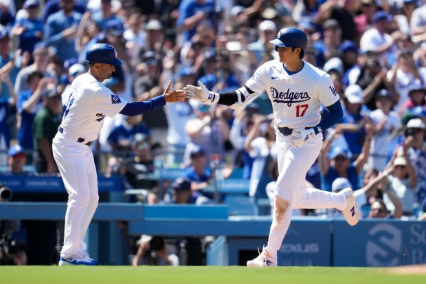 Los Angeles Dodgers designated hitter Shohei Ohtani celebrates with third...