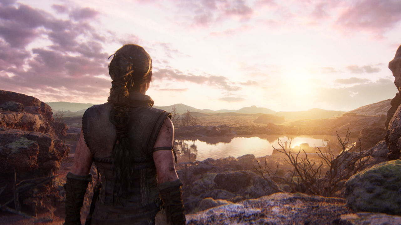 Senua looks out at a mountain over a lake.