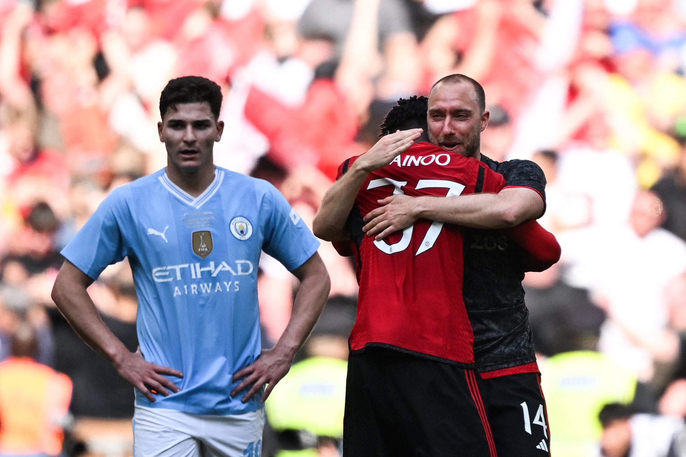 Mainoo is hugged by teammate Christian Eriksen after full-time