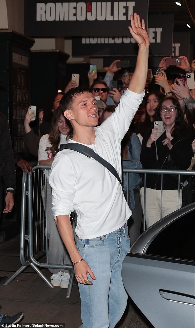 The actor, wearing a plain white t-shirt and jeans, waves to his adoring fans after leaving the theatre