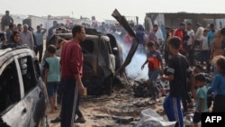 Palestinians gather at the site of an Israeli strike on a camp for internally displaced people in Rafah, May 27, 2024.