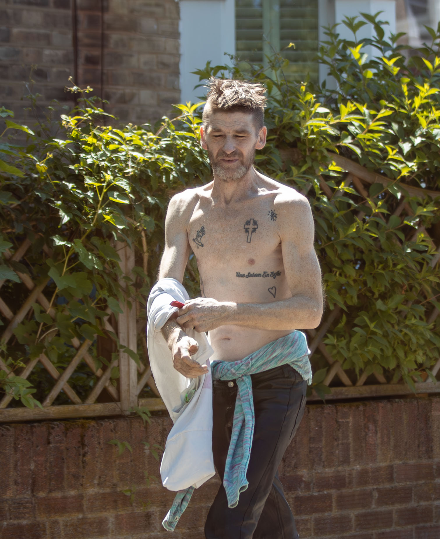 He flashed his tattoos as he soaked up the sunshine in the UK capital