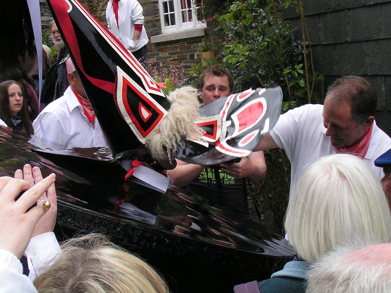 Adjustments being made to the mask of the red 'Oss in Padstow, Cornwall. Photo credit: 
Nomis Elaws on Wikimedia Commons.