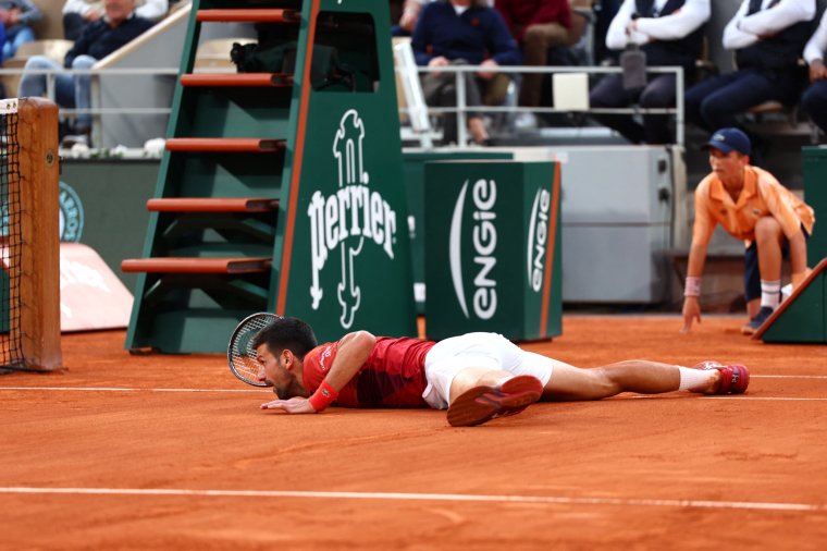 Serbia's Novak Djokovic lays on the court during his men's singles round of sixteen match against Argentina's Francisco Cerundolo on Court Philippe-Chatrier on day nine of the French Open tennis tournament at the Roland Garros Complex in Paris on June 3, 2024. (Photo by EMMANUEL DUNAND / AFP) (Photo by EMMANUEL DUNAND/AFP via Getty Images)