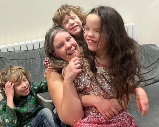 Kate with her kids on the sofa, laughing