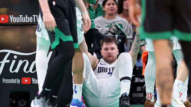 Jun 9, 2024; Boston, Massachusetts, USA; Dallas Mavericks guard Luka Doncic (77) is helped up after a play against the Boston Celtics during the third quarter in game two of the 2024 NBA Finals at TD Garden. Mandatory Credit: Peter Casey-USA TODAY Sports