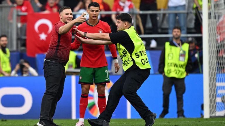 22 June 2024, North Rhine-Westphalia, Dortmund: Soccer: UEFA Euro 2024, European Championship, Turkey - Portugal, preliminary round, group F, match day 2, Dortmund stadium, a man takes a selfie with Portugal's Cristiano Ronaldo during the match. Pic: AP