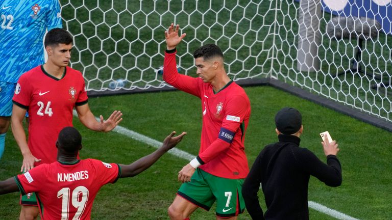 Portugal's Cristiano Ronaldo and his teammates react after a pitch invader ran towards him during a Group F match between Turkey and Portugal at the Euro 2024 soccer tournament in Dortmund, Germany, Saturday, June 22, 2024. (AP Photo/Michael Probst)