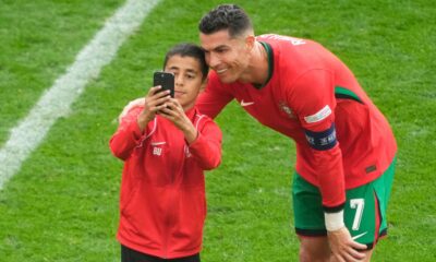 A young pitch invader takes a selfie with Portugal's Cristiano Ronaldo during a Group F match between Turkey and Portugal at the Euro 2024 soccer tournament in Dortmund, Germany, Saturday, June 22, 2024. (AP Photo/Michael Probst)