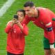 A young pitch invader takes a selfie with Portugal's Cristiano Ronaldo during a Group F match between Turkey and Portugal at the Euro 2024 soccer tournament in Dortmund, Germany, Saturday, June 22, 2024. (AP Photo/Michael Probst)