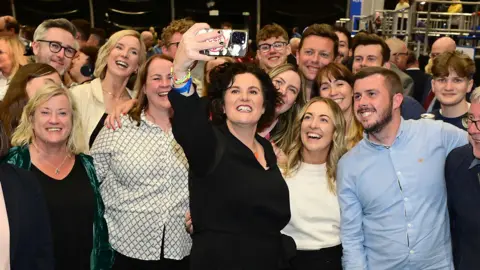 Pacemaker A smiling Claire Hanna takes a selfie while surrounded by ecstatic supporters