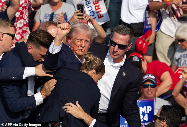 Trump raised a fist as he was taken off the stage by Secret Service members