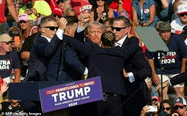 Republican candidate Donald Trump is seen with blood on his face surrounded by secret service agents as he is taken off the stage at a campaign event