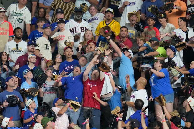 Fans reach for a home run ball during the All-Star...