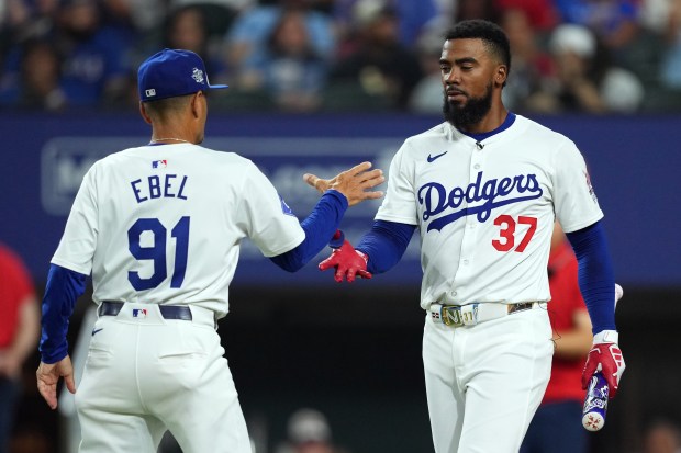 Dodgers outfielder Teoscar Hernández, right, celebrates with third base coach...