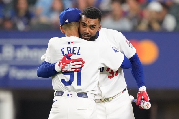 Dodgers outfielder Teoscar Hernández, right, hugs coach Dino Ebel during...