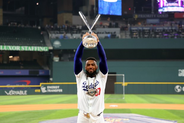 Dodgers outfielder Teoscar Hernández poses with the trophy after winning...