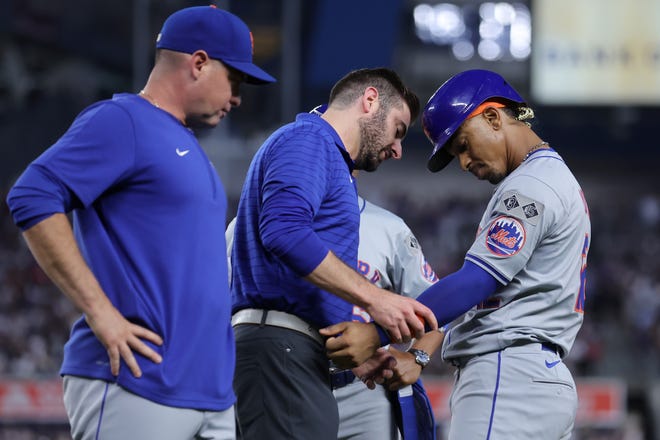 Jul 23, 2024; Bronx, New York, USA; New York Mets shortstop Francisco Lindor (12) is checked out after being hit by a pitch with the bases loaded to drive in a run during the fifth inning against the New York Yankees at Yankee Stadium. Mandatory Credit: Brad Penner-USA TODAY Sports