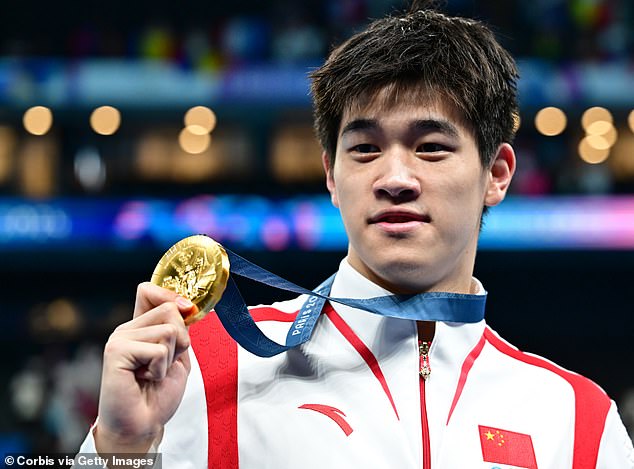 Zhanle poses during with his gold medal after winning the Men's 100m Freestyle