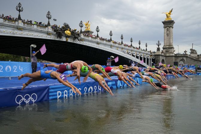 Competitors dive into the Seine River in Paris during the women's Olympic triathlon on July 31. Water quality concerns had postponed the men's triathlon by a day, but it was held on the same day as the women's.