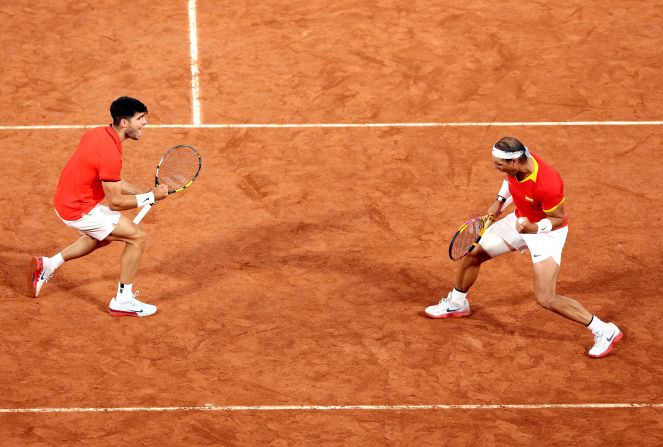 Spanish tennis players Carlos Alcaraz and Rafael Nadal celebrate during a doubles match on July 27. The dream pairing beat Argentina’s Máximo González and Andrés Molteni 7-6, 6-4.