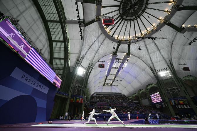 Japanese fencer Miho Yoshimura, left, competes against Rwanda’s Tufaha Uwihoreye in an épée round-of-64 bout on July 27. The Grand Palais, an exhibition hall and event center located off the Champs-Élysées, is the cavernous home to all the fencing competitions at the Paris Olympics.