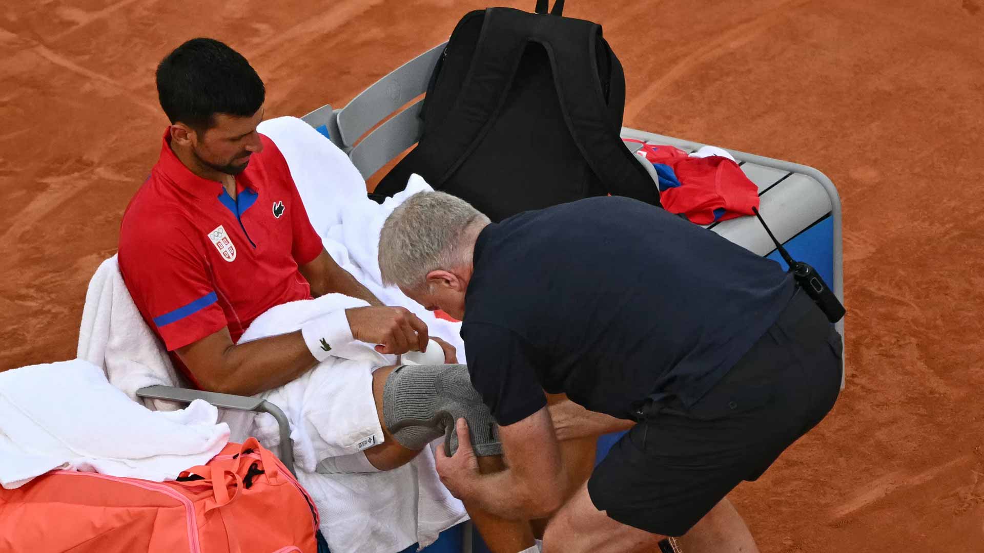 Novak Djokovic visits with the physio Thursday at the Paris Olympics.