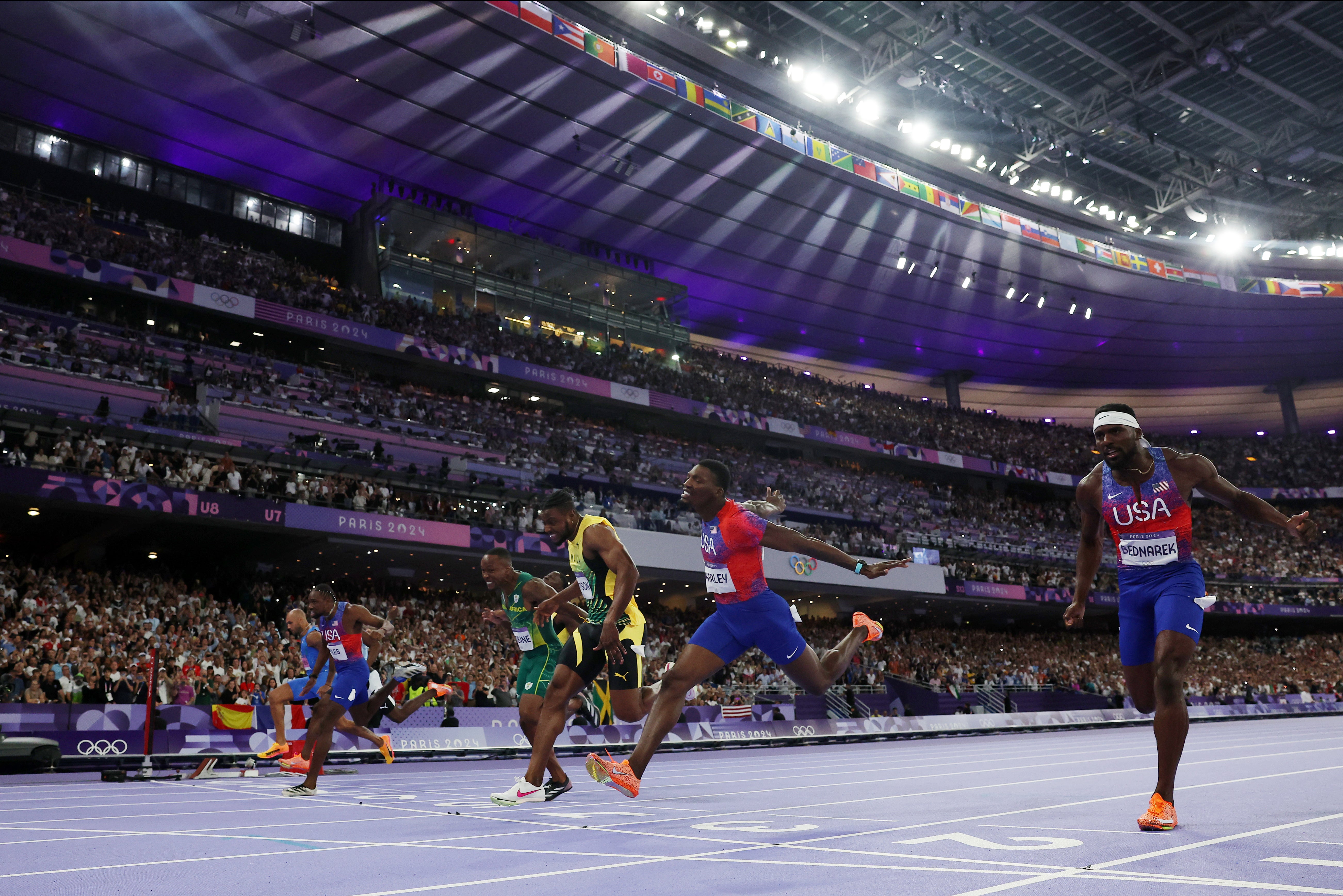 Lyles, far side, pips Thompson and Kerley on the line