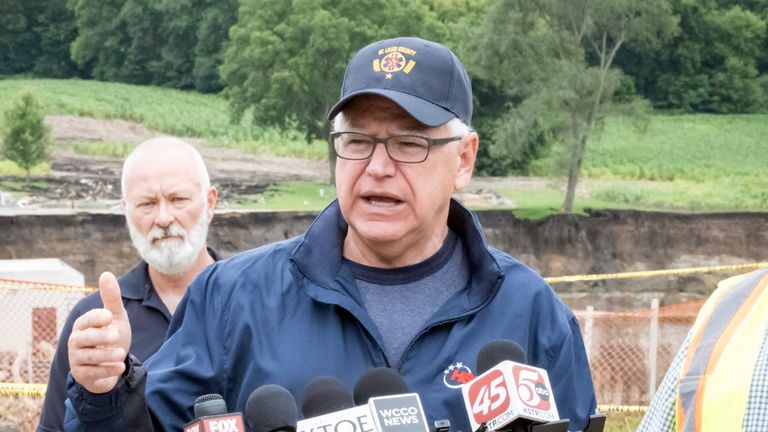 Minnesota Gov. Tim Walz addresses media members Tuesday, July 2, 2024, at the Rapidan Dam, in Rapidan, Minn. Rushing waters from the Blue Earth River have already left a trail of debris and destruction on the edges of a southern Minnesota dam that partially failed last week. (Casey Ek/The Free Press via AP)