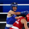 Imane Khelif of Algeria (blue) punches Janjaem Suwannapheng of Thailand during the Women's 66kg semifinal bout on Tuesday at the Paris Olympic Games.