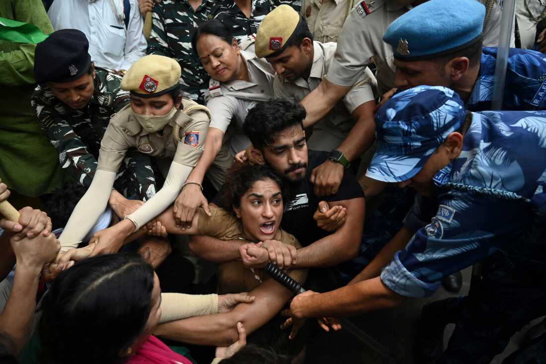 Vinesh Phogat (center) and other elite Indian wrestlers were detained by the police in New Delhi last year as they protested against Brij Bhushan Singh, who was then the wrestling federation chief, over allegations of sexual harassment and intimidation.