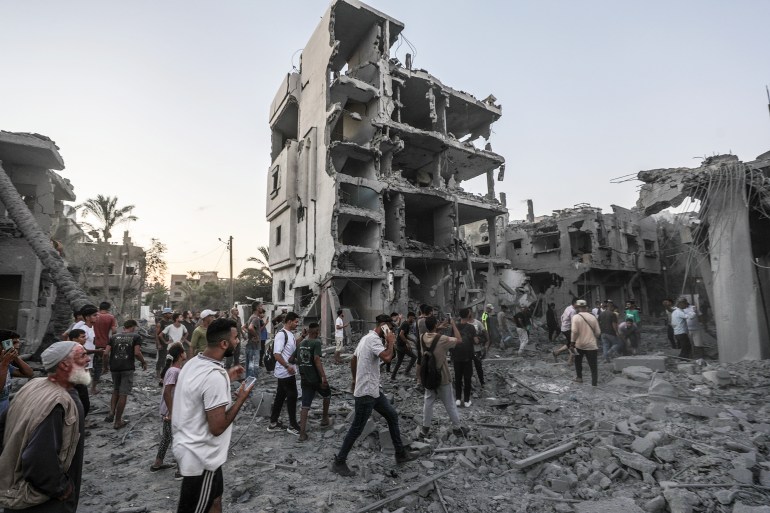 Palestinians inspect damaged houses following an Israeli air strike in the west of Deir Al Balah town