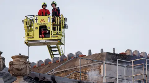 EPA Firefighters in a aerial lift look down on the damage at Somerset House.