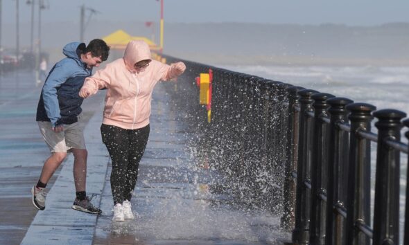 People enjoy the windy conditions and the waves in Tramore in County Waterford. The "remnants" of Hurricane Ernesto are set to batter parts of the UK in the week ahead, bringing heavy rain and wind gusts of up to 60mph, the Met Office has warned. Picture date: Monday August 19, 2024. PA Photo. See PA story Weather Hurricane. Photo credit should read: Niall Carson/PA Wire