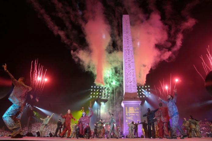 Fireworks light up the sky as dancers perform at the Paris 2024 Paralympics Opening Ceremony