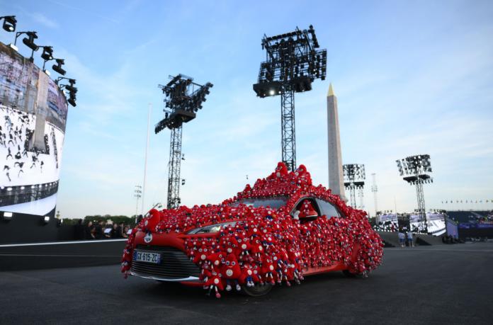 A red car decorated with miniature mascots