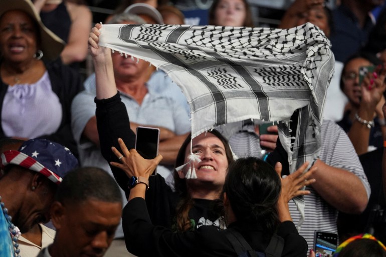 A demonstrator holds up a keffiyeh at Kamala Harris's Savannah rally