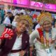 Two athletes dressed in traditional clothing pose for a photograph