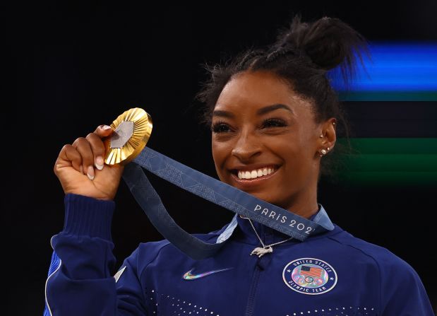 Biles shows off her gold medal — the sixth of her career.